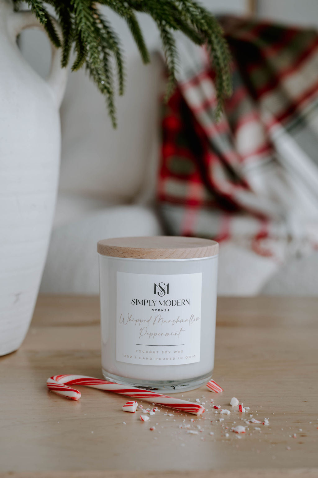Whipped Marshmallow Peppermint white 12 oz candle styled with holiday plaid and winter greenery