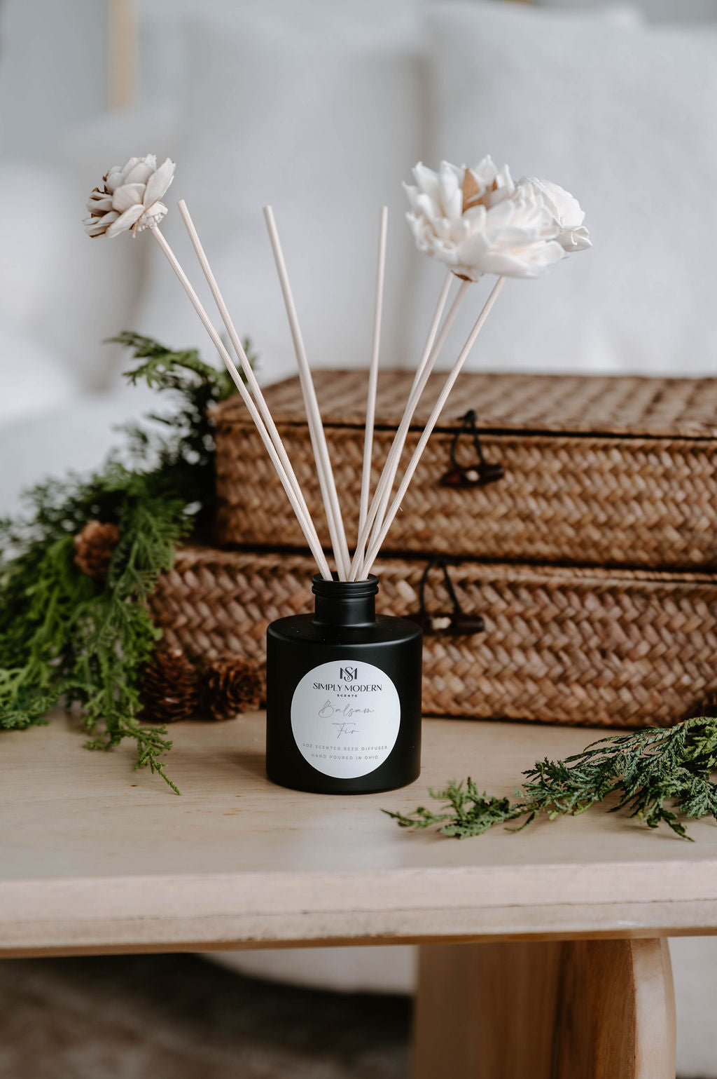 Balsam Fir 4 oz reed diffuser in a matte black bottle with handmade white sola flower reeds