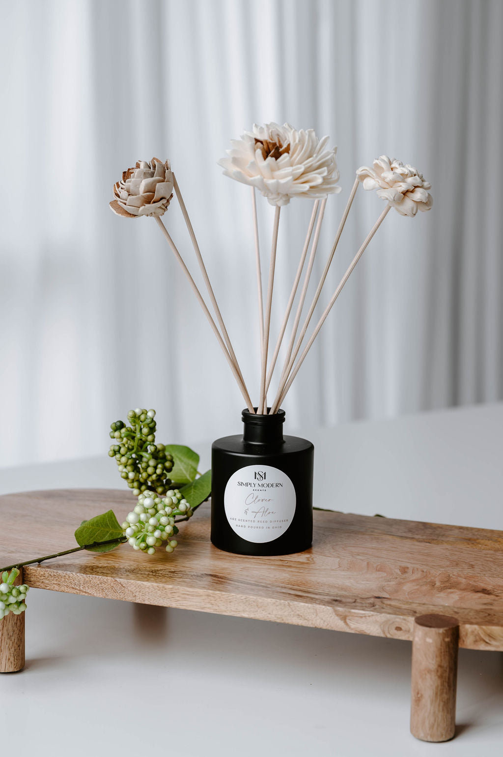 Clover & Aloe 4 oz reed diffuser in a matte black bottle with handmade white sola flower reeds