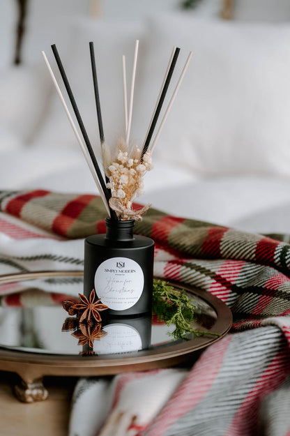Home for Christmas 4 oz reed diffuser in a matte black bottle with mixed black and natural reeds and dried baby's breath