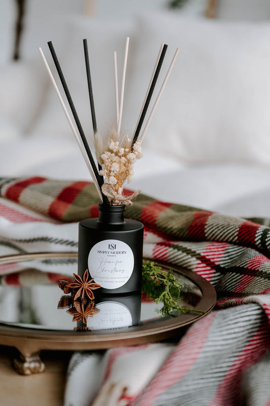 Home for Christmas 4 oz reed diffuser in a matte black bottle with mixed black and natural reeds and dried baby's breath