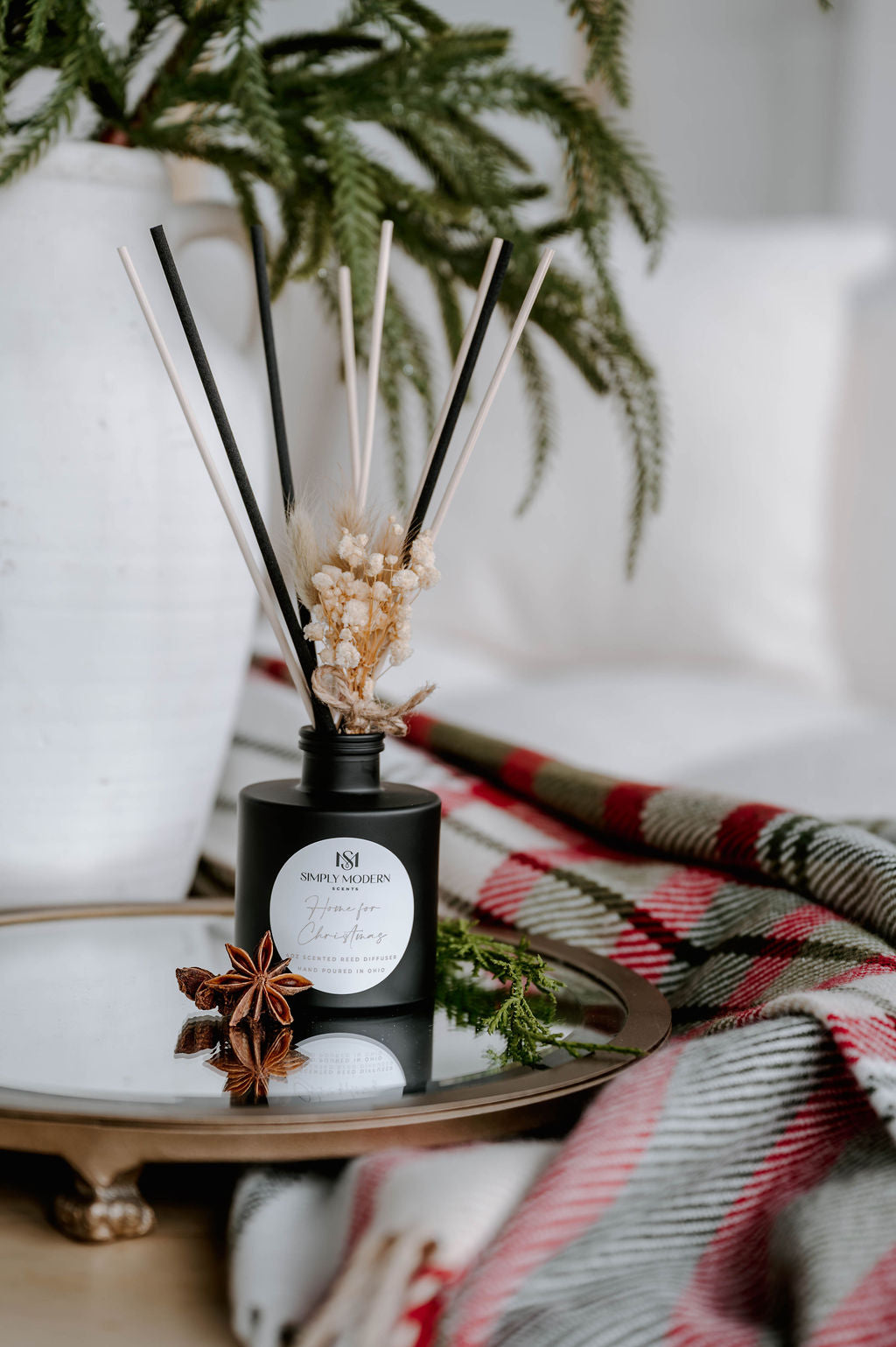 Home for Christmas reed diffuser on a mirrored tray with cedar and holiday plaid