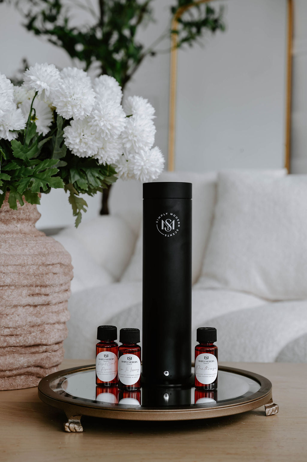 SMS150 luxury electric home diffuser in matte black with 1 oz masculine scent oil bottles on a mirrored tray