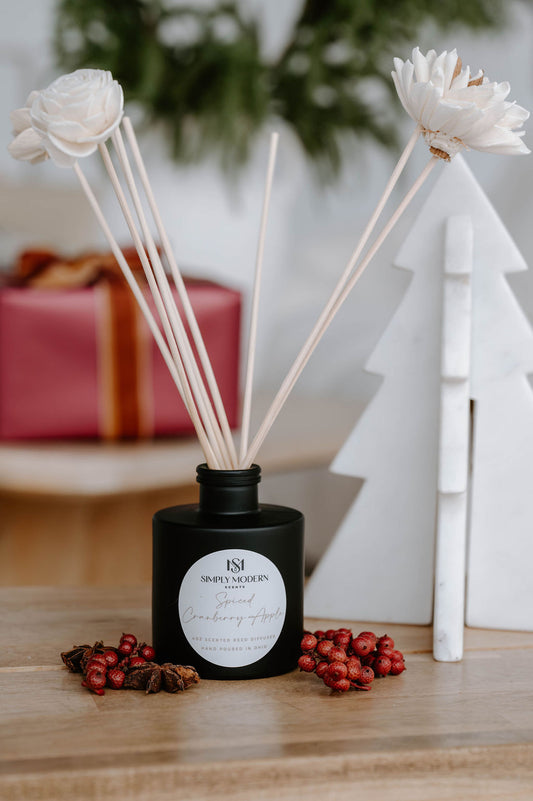 Spiced Cranberry Apple 4 oz reed diffuser in a matte black bottle with handmade white sola flower reeds