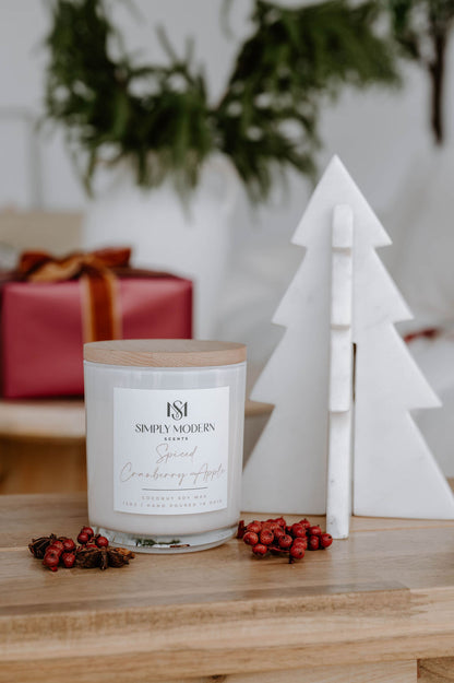Spiced Cranberry Apple 12 oz wood-wick coconut soy candle in a white vessel with a wooden lid, styled with red berries and a marble tree