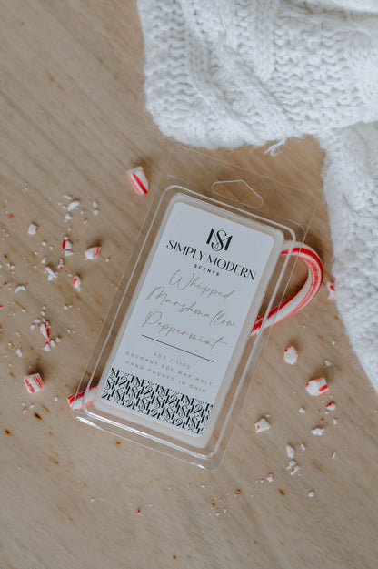 Whipped Marshmallow Peppermint wax melt styled with a white knit throw and crushed peppermint candy